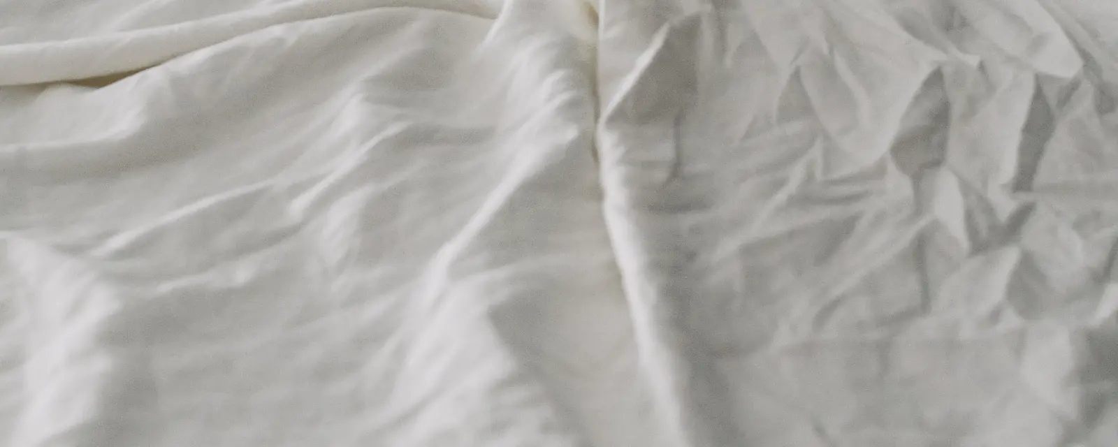 Drap blanc froissé sur un lit